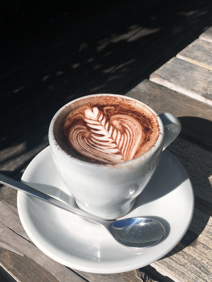 a cup of cappuccino on wooden table